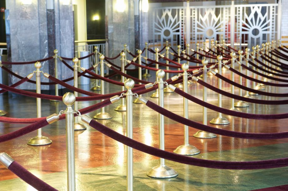 Red and gold Lawrence® Post & Rope in a big hall.